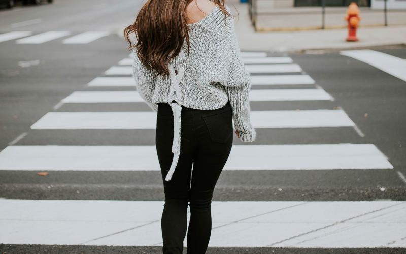Close to the center of everything a person walking in a crosswalk