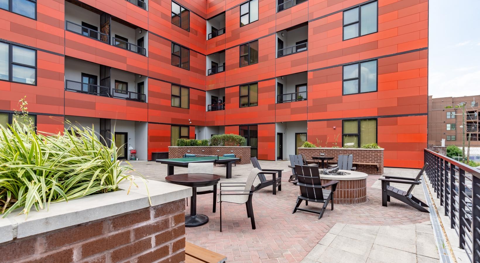 Access to resident-only features a patio with tables and chairs outside a building