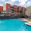 Resort-style swimming pool with lounge seating and building behind it